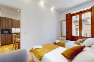 een slaapkamer met 2 bedden en een keuken bij casa nino in Alcalá de Henares