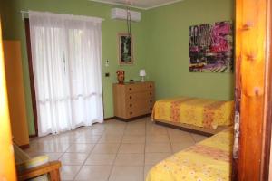 1 dormitorio con 2 camas, vestidor y ventana en PATI'S HOUSE en Giardini Naxos