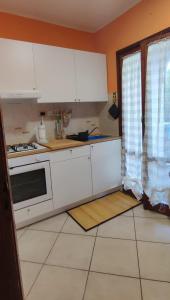 cocina con armarios blancos y fogones en PATI'S HOUSE en Giardini Naxos