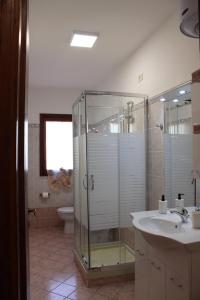 y baño con ducha acristalada y lavamanos. en PATI'S HOUSE en Giardini Naxos