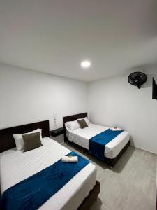 dwa łóżka w pokoju hotelowym z dwoma łóżkami w obiekcie Hotel el tamaco w mieście Ocaña