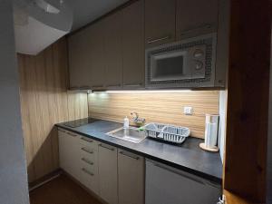 una pequeña cocina con fregadero y microondas en Acogedor apartamento en La Molina, en La Molina