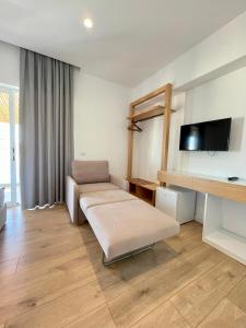 a living room with a couch and a flat screen tv at Hotel Aulona in Sarandë