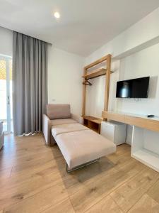 uma sala de estar com um sofá e uma televisão de ecrã plano em Hotel Aulona em Sarandë