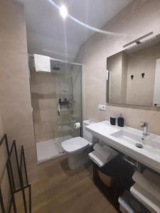 La salle de bains est pourvue de toilettes, d'un lavabo et d'une douche. dans l'établissement Vive el Renacimiento: Cazuela, à Baeza