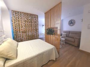 a bedroom with a bed and a couch in a room at Vive el Renacimiento: Cazuela in Baeza