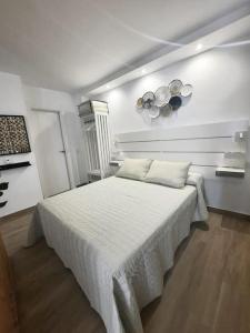 Un dormitorio con una gran cama blanca en una habitación. en Vive el Renacimiento: Cazuela, en Baeza