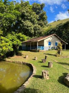 a house next to a body of water at Casinha de Campo com Lago Sítio Luar do Sertão in Bom Jardim