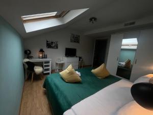 Un dormitorio con una cama verde y blanca y un escritorio en Dreamland Resort, en Zaventem