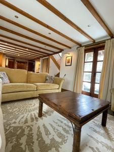 een woonkamer met een bank en een salontafel bij The Old Post House - Historic Dartmoor Home in Tavistock
