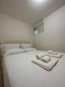 a white bed with towels on top of it at NUMERONOVE Sirolo in Sirolo