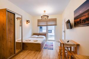 niewielka sypialnia z łóżkiem i stołem w obiekcie Apartamenty,pokoje Paholski w Zubrzycy Górnej