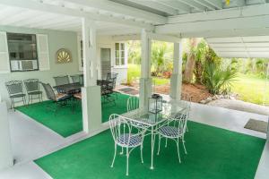 porche acristalado con mesa de cristal y sillas en Palm View: Secluded Oasis in Melbourne Village, 