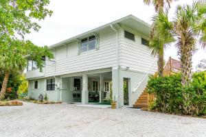 a white house with palm trees in front of it at Palm View: Secluded Oasis in Melbourne Village in Melbourne Village