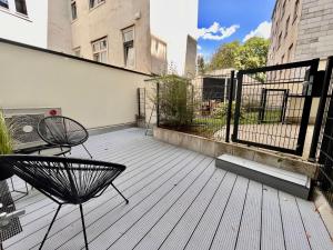 a patio with two chairs and a fence on a balcony at Premium Apartment with Terrace, A/C, FREE WiFi and NETFLIX in Vienna