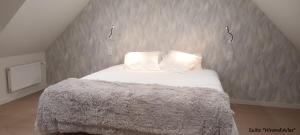 a bed with white sheets and pillows in a room at A la Lueur des Prés in Ducy-Sainte-Marguerite
