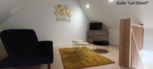 a living room with a chair and a table at A la Lueur des Prés in Ducy-Sainte-Marguerite