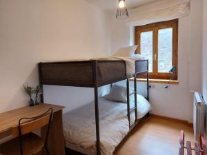 a bedroom with two bunk beds and a desk at Acogedor dúplex en el Valle de Aran in Caneján