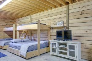 dwa łóżka piętrowe w drewnianym domku z telewizorem w obiekcie Rustic Huntsville Studio with Access to ATV Trails! w mieście Huntsville