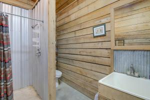 y baño con pared de madera, aseo y bañera. en Rustic Huntsville Studio with Access to ATV Trails!, en Huntsville