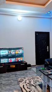 a living room with a flat screen tv and a table at Appart de deux chambres salon scindé en cours unique à Louer in Lomé