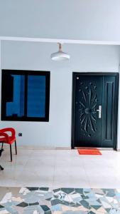 a room with a black door and a red chair at Appart de deux chambres salon scindé en cours unique à Louer in Lomé