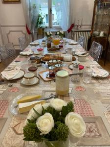 una mesa larga con rosas blancas encima en Villa Dufresne en Beynost