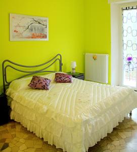 a green bedroom with a bed with two pillows on it at B&B Il Poggio in Villagrande