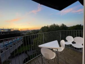 balcón con mesa, sillas y vistas a la ciudad en Cityfront Cosy Apt Near City Centre & Etihad Stadium, Free Parking en Mánchester