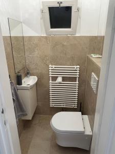 a small bathroom with a toilet and a sink at Tamás Apartman in Székesfehérvár