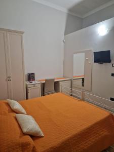 サンニコーラにあるLu Zezzuのベッドルーム1室(オレンジ色のベッドカバー付)