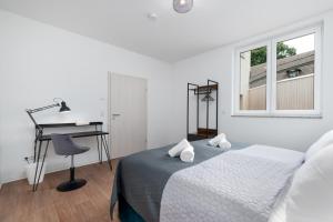 um quarto branco com uma cama e uma secretária em Modernes Apartment, Altstadt, Parkplatz, NETFLIX em Quedlinburg