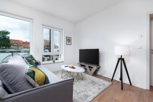 uma sala de estar com um sofá e uma televisão de ecrã plano em Modernes Apartment, Altstadt, Parkplatz, NETFLIX em Quedlinburg
