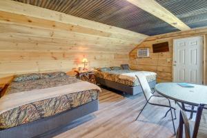 Dormitorio en cabaña de madera con 2 camas y mesa en Cozy Huntsville Escape with Brimstone Trail Access!, en Huntsville