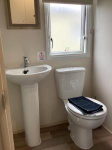 a bathroom with a sink and a toilet and a window at Staycation For You (Kent) in Leysdown-on-Sea