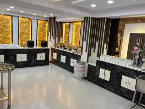 um quarto amplo com um salão de cabeleireiro com lavatórios e espelhos em Hotel Cosmopolitan Rooms & Banquet em Allahabad