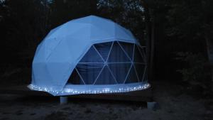 a blue dome tent with lights in the dark at Fundy Spray Campground in Smiths Cove