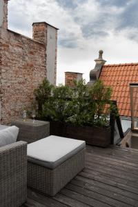 un patio con muebles de mimbre en una terraza de madera en Gotyk na dotyk z tarasem na dachu, en Toruń