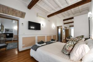a bedroom with a bed and a tv on the wall at Castel Sant'Angelo Apartments - Exclusive & Luxury in Rome