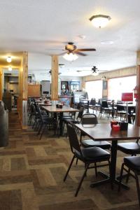 a restaurant with tables and chairs and a ceiling fan at Gold Country Inn in Deadwood