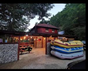 Ein Haus mit einem Haufen aufblasbarer Boote davor in der Unterkunft Hostel Raft Neretva in Konjic