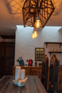 una lámpara de araña colgada sobre una mesa de madera en la cocina en Gotyk na dotyk z tarasem na dachu, en Toruń