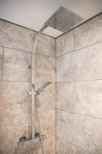 a shower with a shower head in a bathroom at Newly Renovated 2 Bed house in Penryn