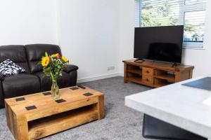 a living room with a couch and a table with a tv at Newly Renovated 2 Bed house in Penryn