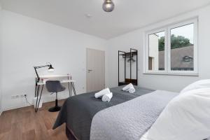 奎德林堡的住宿－Design-Wohnung, Altstadt, Parkplatz, NETFLIX，白色的卧室设有床、书桌和窗户