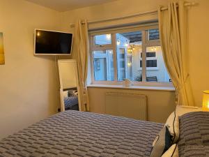 a bedroom with a bed and a window at Seagull Cottage in Holyhead