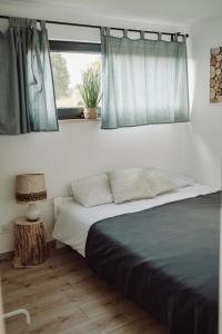 Schlafzimmer mit einem Bett und einem Fenster in der Unterkunft Osada Przejrzysko in Jordanów