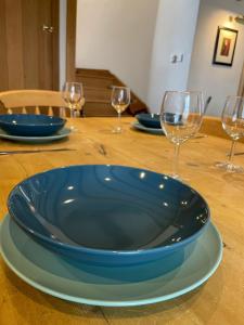 um prato azul numa mesa de madeira com copos de vinho em The Old Post House - Historic Dartmoor Home em Tavistock