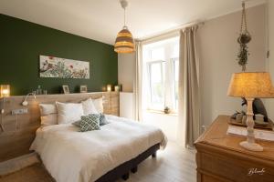 een slaapkamer met een groot bed met een groene muur bij LE MANOIR DE LA VALETTE in Florennes