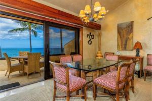 a dining room with a table and chairs and the ocean at MAKENA SURF #B304 condo in Wailea